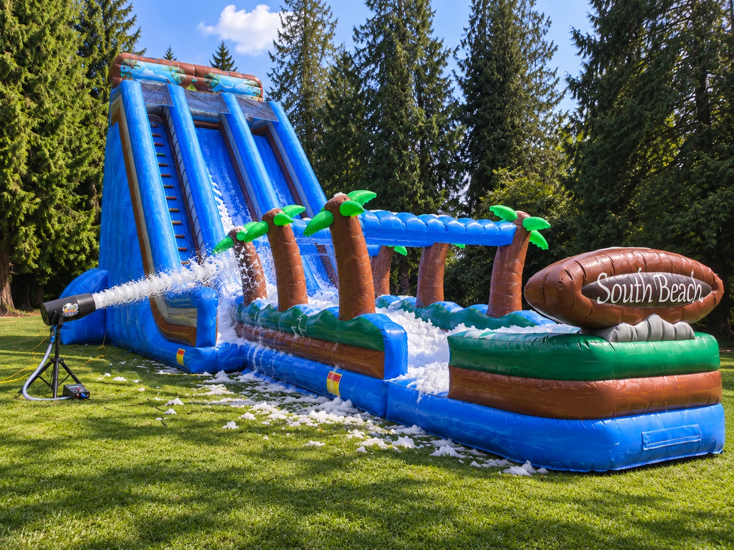 Large blue inflatable bounce house with an Olympic Ridge Supply foam machine creating foam beside it